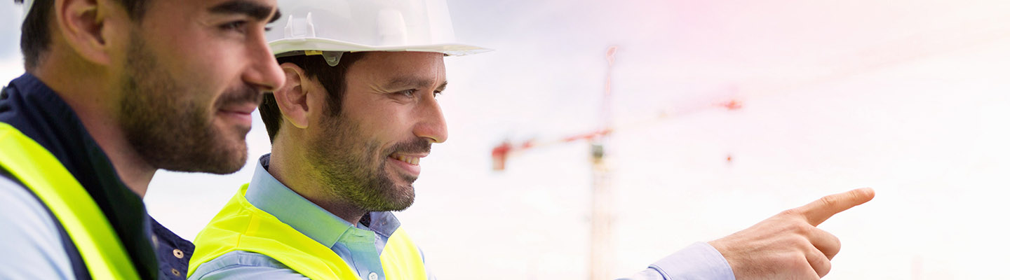Worker and architect watching some details on a construction View of a Worker and architect watching some details on a construction